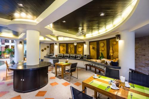 a restaurant with tables and chairs and a bar at Dara Samui Beach Resort Adults Only, Chaweng in Chaweng