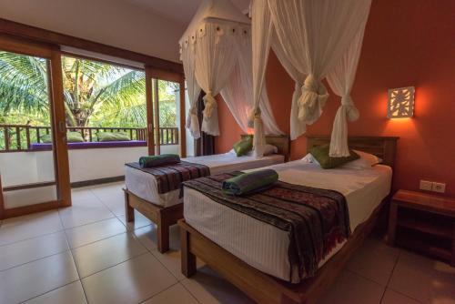 Ένα ή περισσότερα κρεβάτια σε δωμάτιο στο Arjuna Homestay