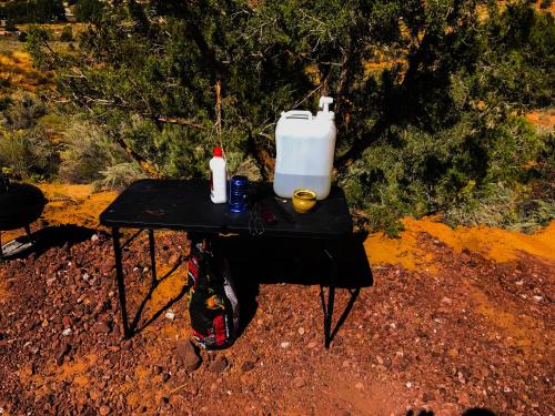a picnic table with a drink and a jug on it at Zion View Camping in Hildale