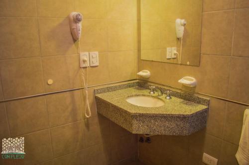 a bathroom with a sink and a phone on the wall at Piraka´s in Gualeguaychú