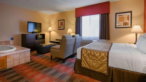 a hotel room with a bed and a bathroom at Best Western Dallas Inn & Suites in Dallas