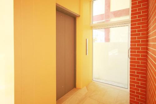 a door in a room with a window and a brick wall at Happy Hostel in Pattaya Central