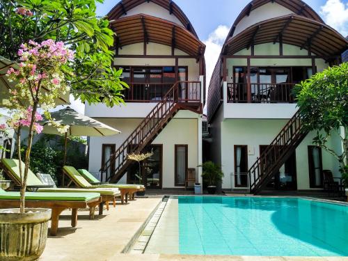 a hotel with a swimming pool in front of a building at Naturela in Uluwatu