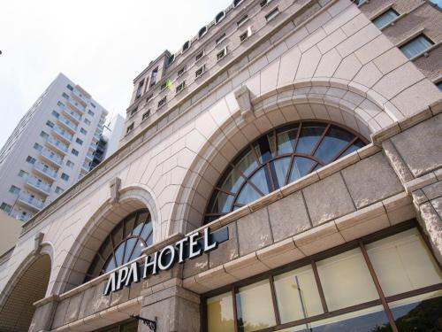 a building with a sign on the side of it at APA Hotel Matsuyamajo Nishi in Matsuyama