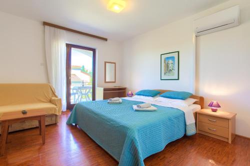 a bedroom with a bed with a blue blanket at Apartments Vlatko in Krk