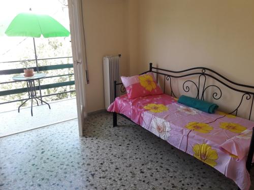 a bedroom with a bed with pink sheets and a green umbrella at Hellas Palace Rooms CENTER in Sparti