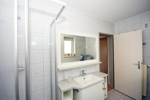 La salle de bains blanche est pourvue d'un lavabo et d'un miroir. dans l'établissement Ferienwohnung Loipersdorf, à Loipersdorf bei Fürstenfeld