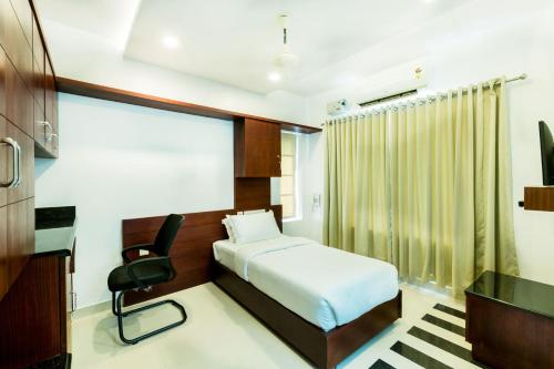 a bedroom with a bed and a desk and a chair at Omnest in Cochin