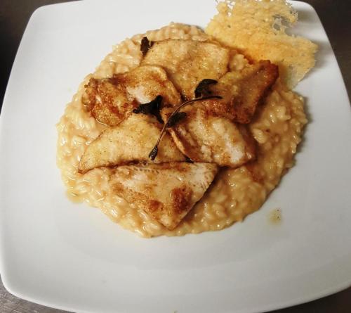 a plate of food with chicken and risotto at Albergo Ristorante Lavedo in Lenno
