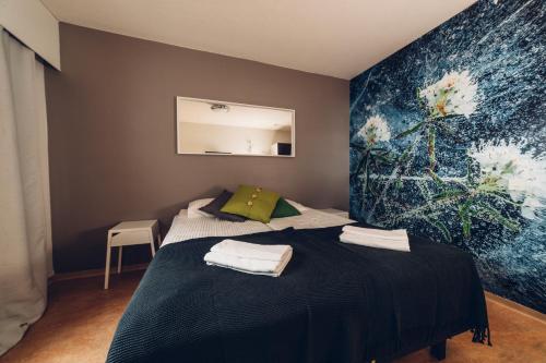 a bedroom with two beds and a painting on the wall at Hotel Kittilä in Kittilä