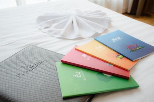 three books sitting on top of a bed at Prajaktra Design Hotel in Udon Thani