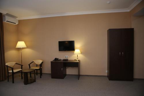 a hotel room with a desk and a tv on the wall at Hotel Aner in Astana