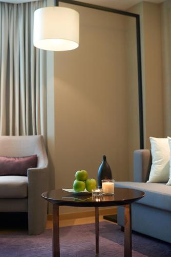 a living room with a coffee table and a lamp at Wharney Hotel in Hong Kong