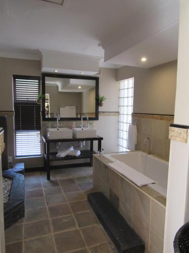 a large bathroom with a tub and a sink at Fairways Hotel in Ballito