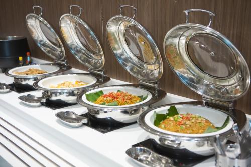 a row of plates of food on a table at Holiday Inn Express Jakarta International Expo by IHG in Jakarta