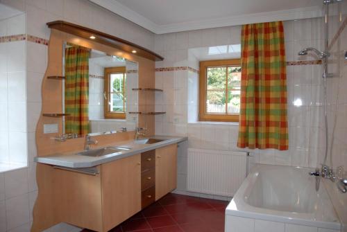 a bathroom with two sinks and a tub and a tubermott at Ferienwohnungen Familie Aigner in Katschberghöhe