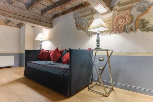a black couch with red pillows in a room at Palazzo Del Carretto-Art Apartments and Guesthouse in Turin