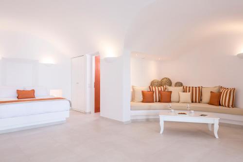 a white living room with a couch and a table at Amber Light Villas in Imerovigli