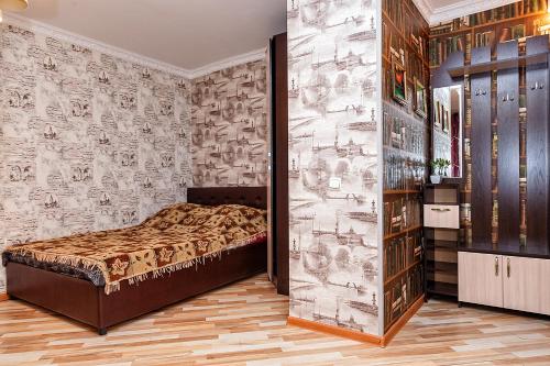 a bedroom with a bed and a wall of wallpaper at квартира в центре, 50 Лет Октября 12 in Kemerovo