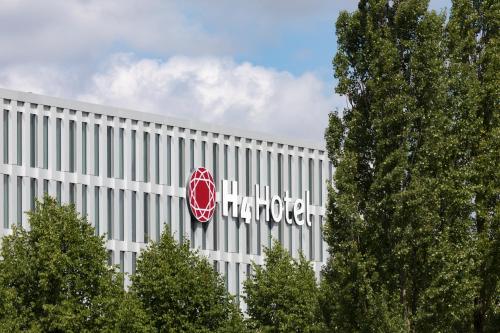 a large white building with a harrods sign on it at H4 Hotel München Messe in Munich