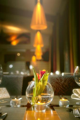 a table with a glass bowl with a flower in it at Hotel Lasaretti in Oulu
