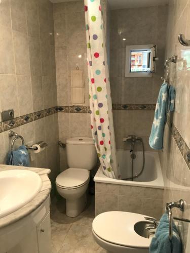 a bathroom with a toilet and a sink and a shower curtain at Eucalytus I in Salou