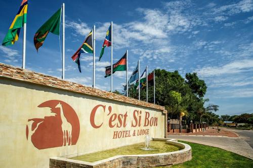 a building with a flag on top of it at Cest Si Bon Hotel in Otjiwarongo
