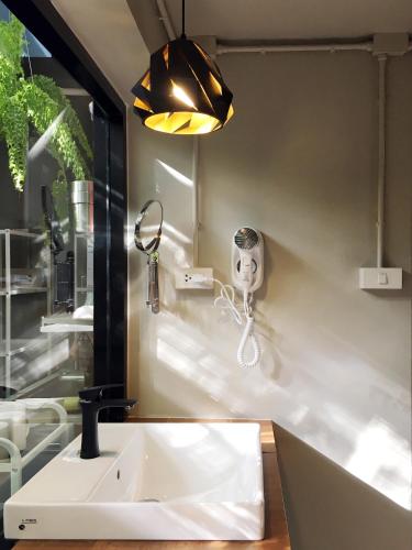 a bathroom with a sink and a mirror at Monomer Hostel Bangkok in Bangkok