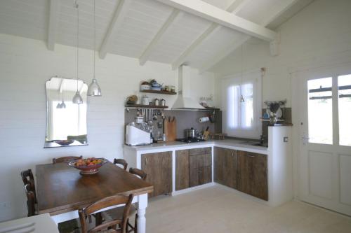una cucina con tavolo in legno e frigorifero di Chalet Il Bosco dei Mille Frutti a Canossa