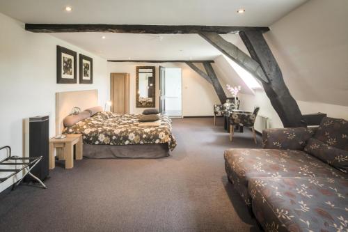 a bedroom with a bed and a couch at Hotel Kasteel Doenrade in Doenrade