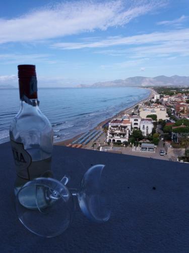 a bottle and glasses sitting on a ledge overlooking the ocean at Florenza Residence in Sperlonga