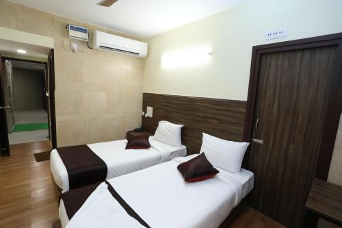 a hotel room with two beds and a window at Season 4 Residences - Nungambakkam Near US consulate, Apollo Hospital, Shankar Nethralaya in Chennai