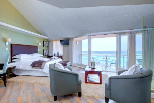 a large bedroom with a bed and a balcony at Dune Villa Wilderness in Wilderness