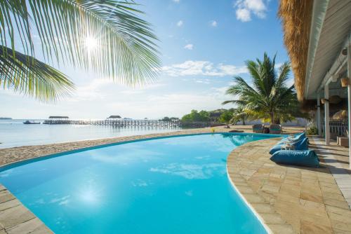 a large blue swimming pool next to the water at Sudamala Resort, Seraya, Flores in Labuan Bajo