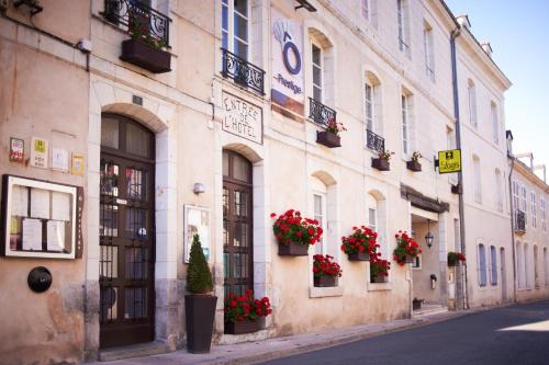 a building with flower boxes on the side of a street at O Prestige in Baugé-en-Anjou