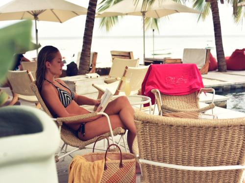 a woman in a bikini sitting in a chair with a laptop at The Bay in Rivière Noire