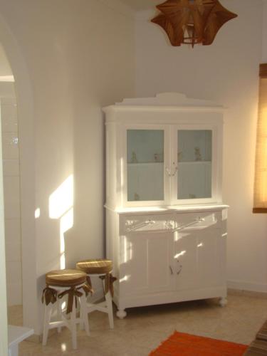 a white cabinet with two stools in a room at Vivenda tilia in Pernes