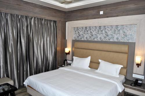 Hotel Continental Blue في بيكانير: غرفة نوم مع سرير أبيض كبير في غرفة