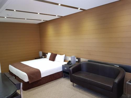 une chambre d'hôtel avec un lit et une chaise dans l'établissement Moura Meridian Motel, à Moura