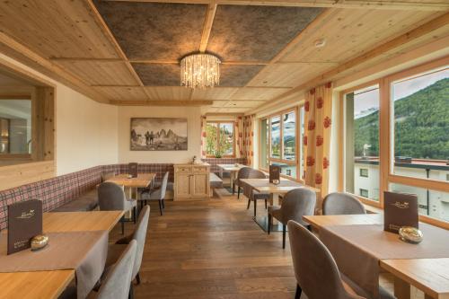 a restaurant with tables and chairs and windows at Hotel Waldhof in Perca