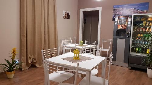 a dining room with white tables and a refrigerator at B&B Stella Maris Sciacca Centro in Sciacca