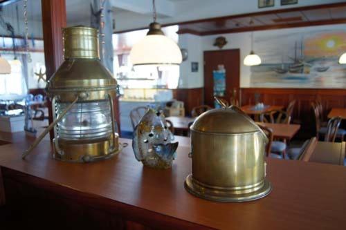 two metal containers and a bottle on a table at Gästehaus Restaurant Norddeich in Norddeich