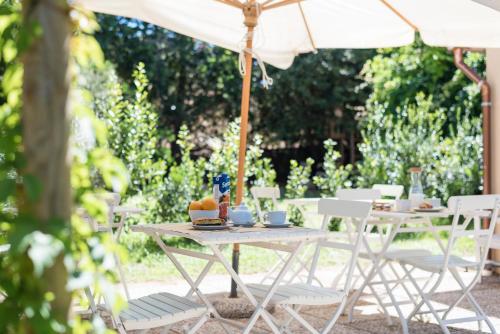 an outdoor table and chairs with an umbrella at Fattoria Pian Di Rocca in Castiglione della Pescaia