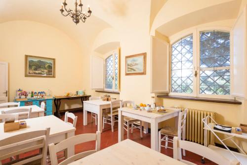 a restaurant with tables and chairs and windows at Fattoria Pian Di Rocca in Castiglione della Pescaia