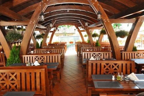 un restaurante con mesas de madera y sillas de madera en Pensiunea Nora, en Timisoara