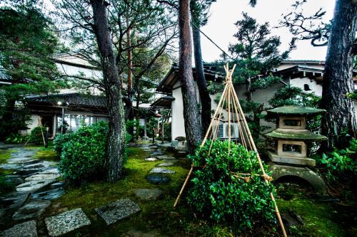 a garden with a stone walkway in front of a house at Yamanoo in Kanazawa