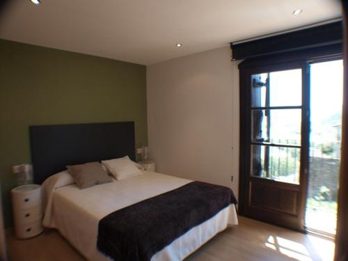 um quarto com uma cama e uma grande janela em El Mirador de Ainsa em Aínsa