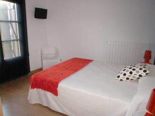 a bedroom with a white bed with a red blanket at El Mirador de Ainsa in Aínsa