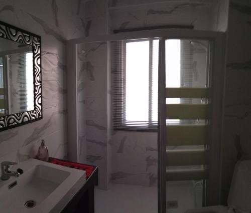 a bathroom with a sink and a shower and a window at Piso Vacacional in San Juan de Alicante