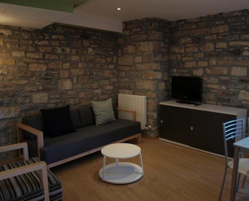 a living room with a couch and a tv at El Mirador de Ainsa in Aínsa